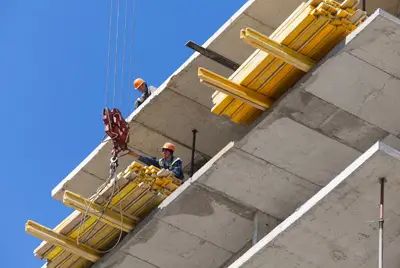 Рабочие ведут монтаж конструкций верхних этажей Рабочие ведут монтаж конструкций верхних этажей