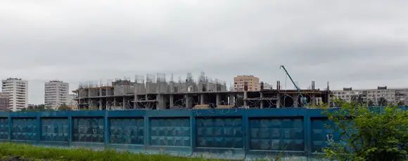 Рабочих не видно, но из-за забора слышен звук «болгарки»