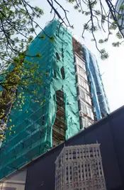 Затянутый сеткой фасад облицуют отделочным камнем – как на картинке